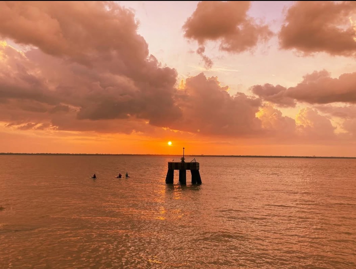 Sunset over water with pier